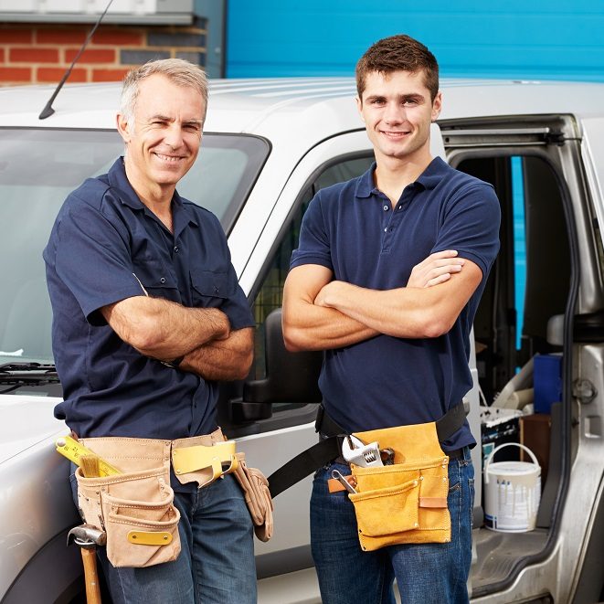 Workers In Family Business Standing Next To Van